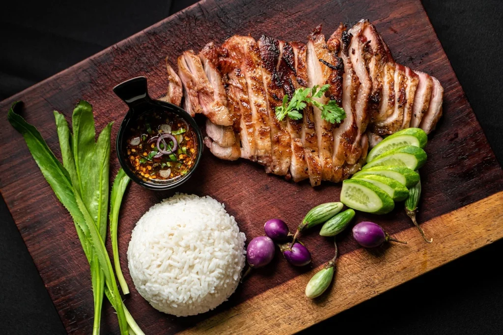 "Thai BBQ with the Best BBQ Tool Set - A mouthwatering Thai BBQ spread on a grill with a variety of grilled meats, veggies, and seafood."